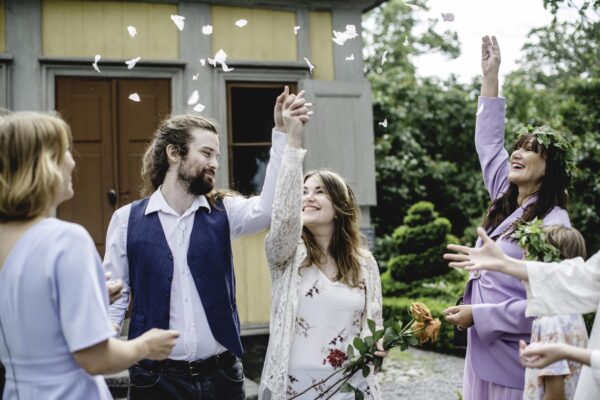 Ett par som just har vigt sig på Skansen. De håller varandra i handen medans deras gäster hurrar och kastar konfetti.