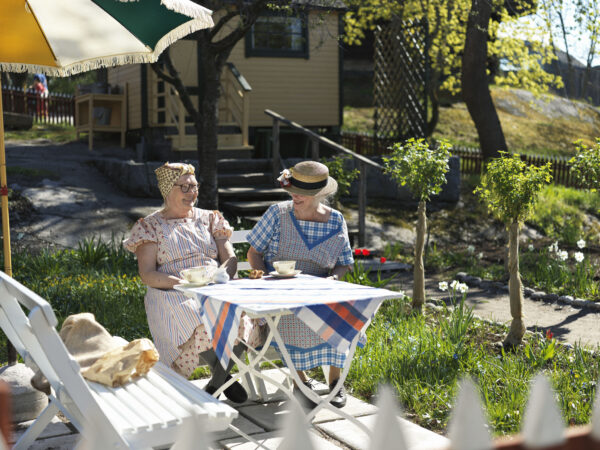 Två damer fikar i Skansens kolonistuga
